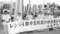 都市型戦闘訓練施設に抗議してデモ行進をする伊芸区の住民ら=27日、沖縄県金武町伊芸区