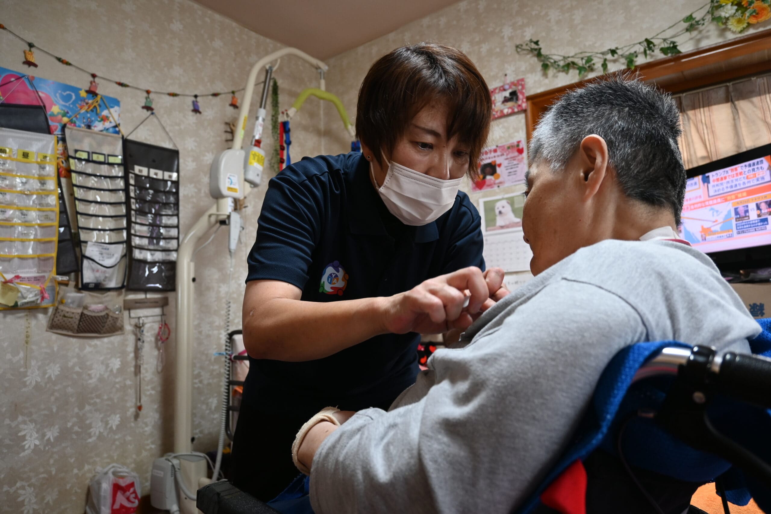 女性利用者を訪問し、薬を貼り替えるホームヘルパーの雨宮さん=4日、山梨県南アルプス市